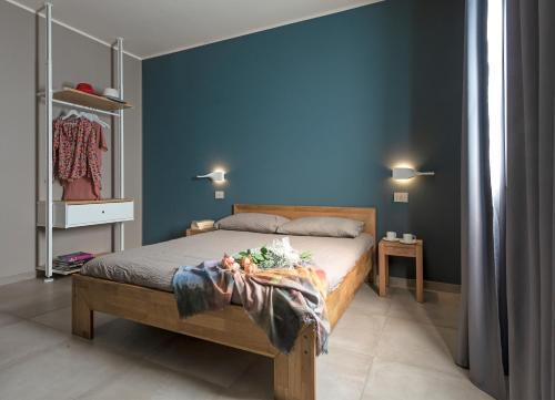 a bedroom with a bed with a blue wall at d'Ocalée Holiday Experience lago d'Orta in Omegna