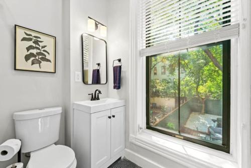 a bathroom with a white toilet and a window at Newly Renovated 2BR Haven Walk to Columbia Uni in New York