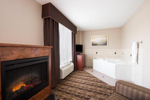 ein Wohnzimmer mit einem Kamin und einer Badewanne in der Unterkunft Holiday Inn Express & Suites Douglas, an IHG Hotel in Douglas