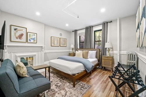 a bedroom with a bed and a couch and a fireplace at Newly Renovated 2BR w Rare Private Backyard and BBQ in New York