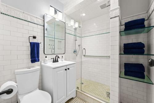 e bagno con servizi igienici, lavandino e doccia. di Newly Renovated 2BR w Rare Private Backyard and BBQ a New York