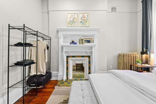 a white bedroom with a fireplace and a bed at 3BR Retreat Walkable to Columbia University in New York