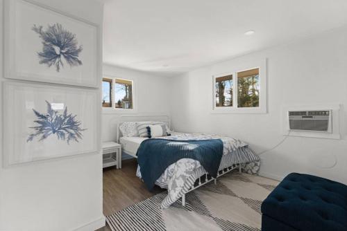 um quarto com uma cama e uma cadeira azul em Waterfront Newly Renovated w Amazing Views em Oak Bluffs