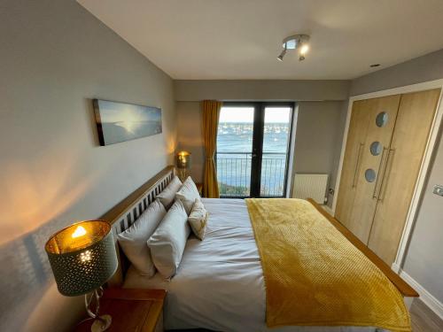 um quarto com uma cama grande e uma janela em Corinthian Quay Apartment em Edimburgo