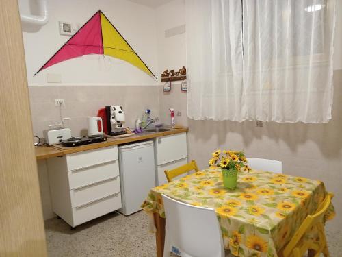 カステルヌオーヴォ・ディ・ポルトにあるA1 Girasole B&Bのキッチン(テーブル、上に掛けられた凧付)