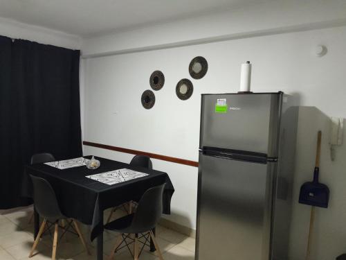 a dining room with a table and a refrigerator at Monteagudo 847 in San Miguel de Tucumán