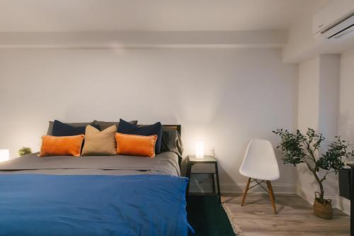 a bedroom with a bed with orange and blue pillows at 2Beds Apt walking distance to major hospitals - heart of Morris Park - Bronx 30 days plus in Morris Park