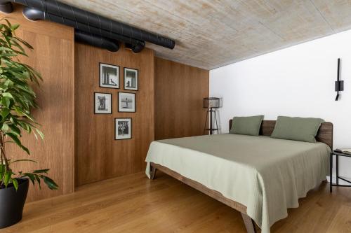 um quarto com uma cama e uma parede de madeira em Stylish loft with terrace Paupys, Old town em Vilnius