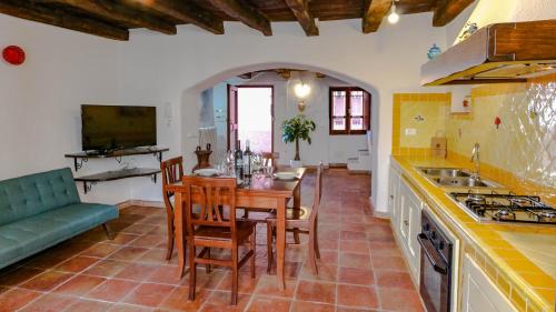 a kitchen with a table and chairs and a couch at Casa Clara in Mamoiada