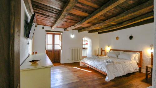 - une chambre avec un lit dans une pièce dotée de plafonds en bois dans l'établissement Casa Clara, à Mamoiada