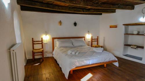 a bedroom with a bed and two chairs in it at Casa Clara in Mamoiada