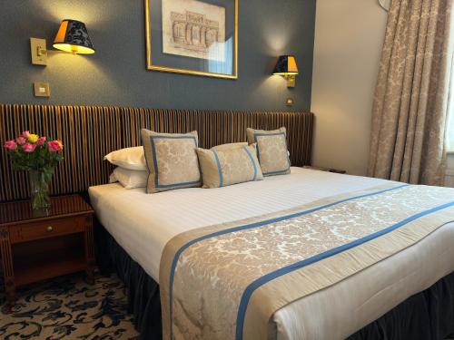 una camera d'albergo con un grande letto con cuscini di London Lodge Hotel a Londra