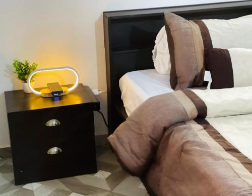 1 dormitorio con 1 cama y mesita de noche con espejo en Appartements meublés - Cozy House Bénin en Cotonú
