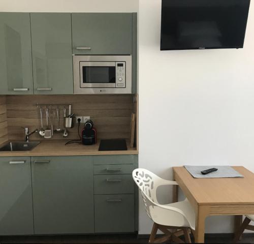 a kitchen with a table and a microwave at Schindler in Münchendorf