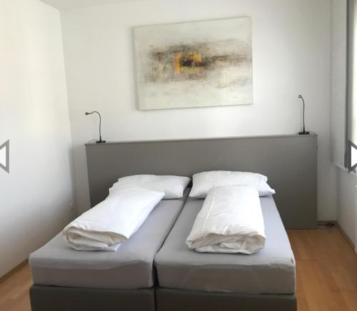 Bett mit drei Kissen auf einem Zimmer in der Unterkunft Schindler in Münchendorf
