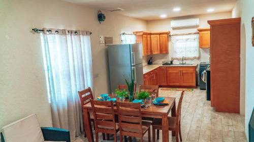a kitchen with a table with chairs and a refrigerator at SKYLINE SUITES: 3 BED/3 BATH VACATION RENTAL in Grand Anse