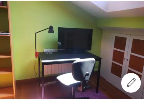 escritorio con ordenador y silla en una habitación en Loft cerca de la playa, en Sopelana