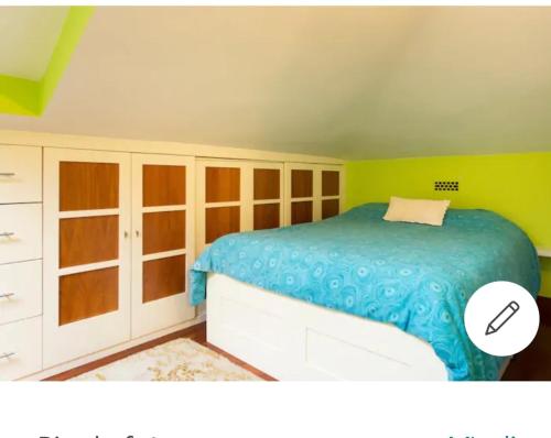 um quarto com uma cama e uma parede amarela em Loft cerca de la playa em Sopelana