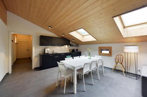 a kitchen and dining room with a white table and chairs at Luna Elk Home in Lenk