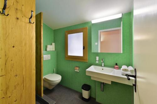 een groene badkamer met een wastafel en een toilet bij Luna Elk Home in Lenk