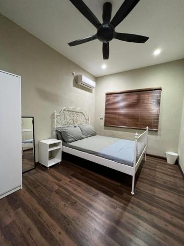 - une chambre avec un lit et un ventilateur de plafond dans l'établissement Teratak LS Homestay, à Kubang Semang