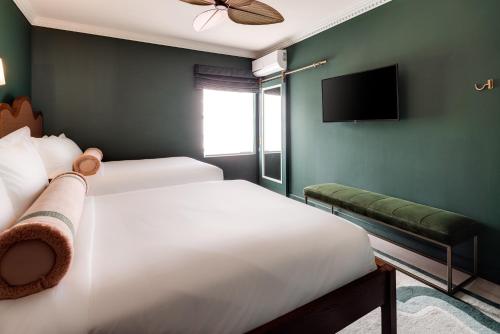 a bedroom with two beds and a flat screen tv at Esme Miami Beach in Miami Beach