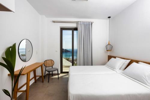 a hotel room with two beds and a desk at "Thea" Luxury Apartments with great View in Plakias