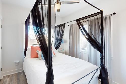 a bedroom with a black canopy bed with white sheets at Red Rock Retreat in Big Water