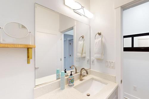 a white bathroom with a sink and a mirror at Red Rock Retreat in Big Water