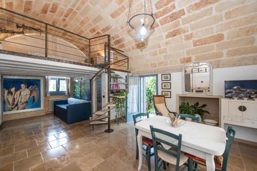 un soggiorno con tavolo, sedie e muro di mattoni di Apartments in Spongano/Apulien 20947 a Spongano
