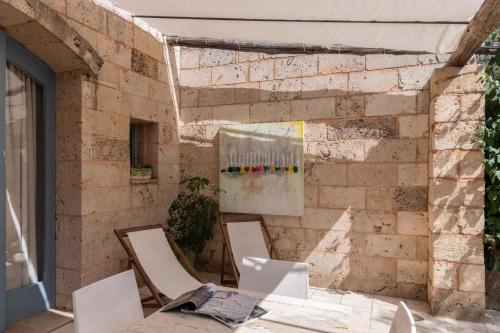 una stanza con sedie e un dipinto su un muro di mattoni di Apartments in Spongano/Apulien 20947 a Spongano