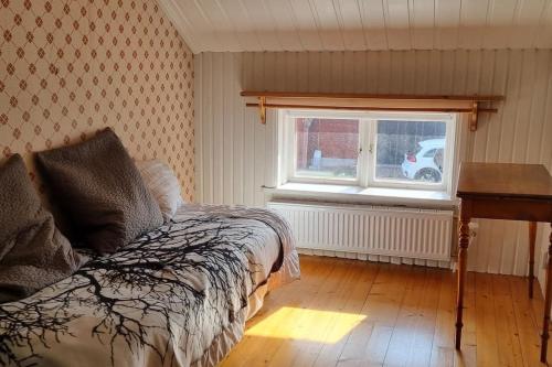 a bedroom with a bed and a window and a desk at Rymlig dalastuga i Siljansnäs 4-6 bäddar in Siljansnäs