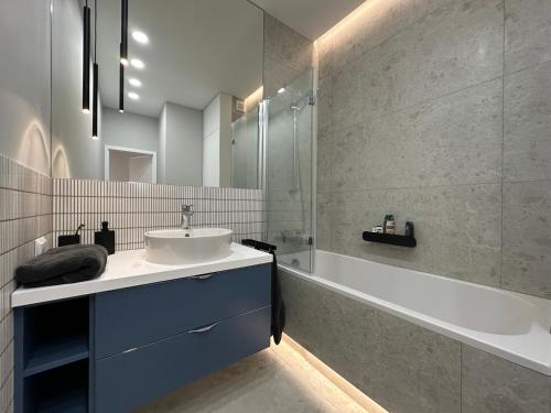 La salle de bains est pourvue d'un lavabo et d'une baignoire. dans l'établissement Odrzańska 17B Apartment - Self Check-In 20h, à Wrocław