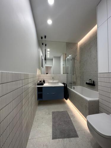 La salle de bains est pourvue d'un lavabo, d'une baignoire et de toilettes. dans l'établissement Odrzańska 17B Apartment - Self Check-In 20h, à Wrocław