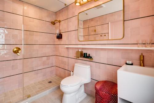 a pink bathroom with a toilet and a mirror at Esme Miami Beach in Miami Beach