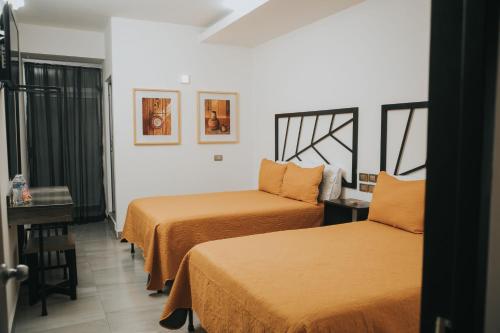 a hotel room with two beds and a window at MCI HOTEL in San Juan de los Lagos