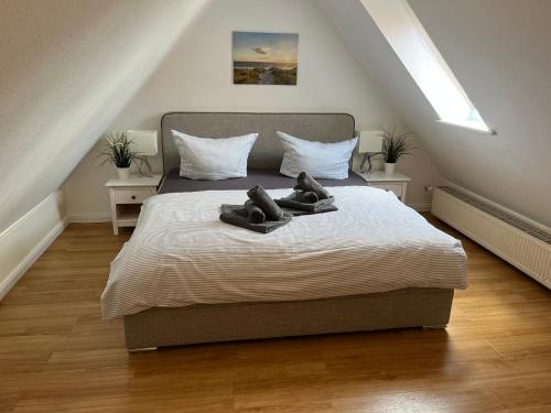 een slaapkamer met een bed met twee schoenen erop bij Friesenhof 8G in Grömitz