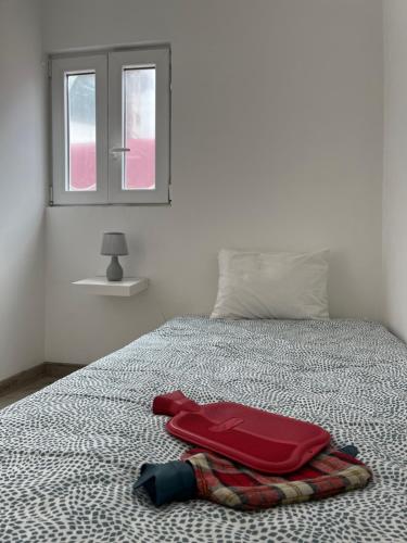 ein Bett mit einer Decke und einem roten Koffer darauf in der Unterkunft Perfect Apartment Mouraria in Lissabon