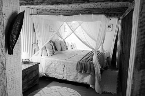 a bedroom with a canopy bed with a window at VILA TRANCOSEAR in Trancoso