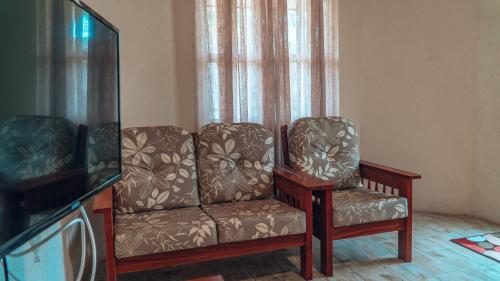 sala de estar con sofá y TV en SKYLINE SUITES: 3 BED/3 BATH VACATION RENTAL en Grand Anse