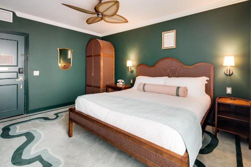 a bedroom with a large bed with green walls at Esme Miami Beach in Miami Beach