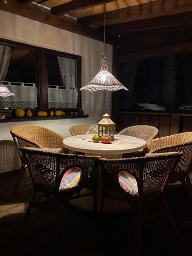 a dining room table with chairs and a light fixture at Domki Zielone Wzgórze 606-819-046 in Polańczyk