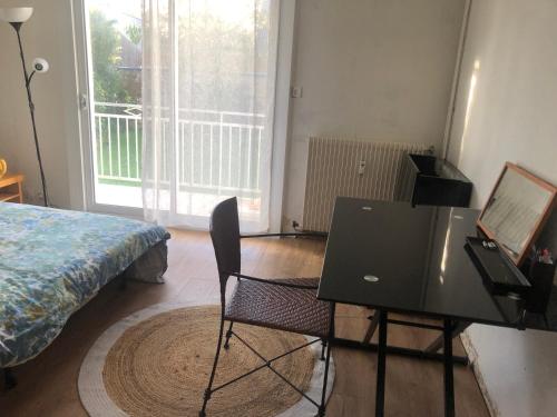 um quarto com uma secretária e uma mesa com uma cadeira em Studio proche sentiers côtiers em Vannes
