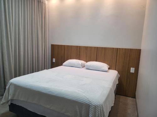 een slaapkamer met een bed met 2 kussens erop bij Pousada Casa de Praia in Brejo Sêco