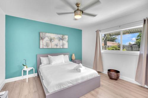 a bedroom with a white bed and a blue wall at Blue Wave Bungalow - 1 1 - Stylish in Dania Beach