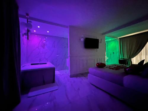 Habitación púrpura con cama y bañera en ANAMA camere & suite, en Lucera