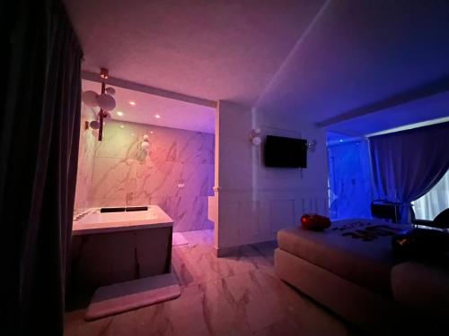 Habitación oscura con cama y luz morada en ANAMA camere & suite, en Lucera