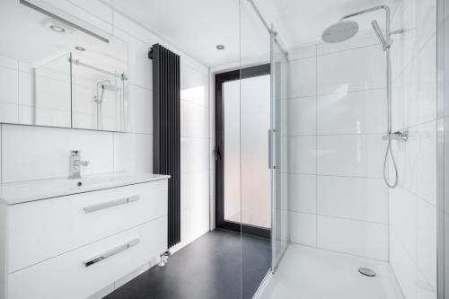 een badkamer met een glazen douche en een wastafel bij Holiday Home Maridu Forest Cube in Arnhem