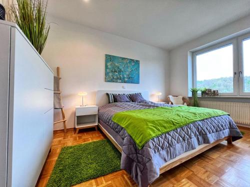 a bedroom with a bed and a large window at 4-Sterne Ferienwohnung Waldblick Schweinfurt in Schweinfurt