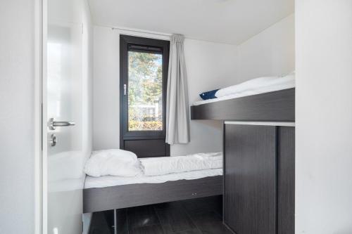 een kamer met 2 stapelbedden en een raam bij Holiday Home Maridu Family L-Cube in Arnhem